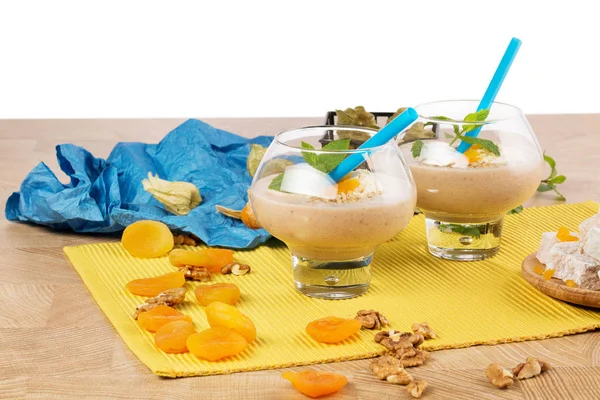 Un paio di bicchieri da dessert isolati su sfondo bianco. Frullati accanto alle albicocche secche, delizia turca e physalis . — Foto Stock