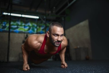 Seksi kas adam bir push-up spor yapıyor. Yakışıklı adam kaslı bir vücut üzerinde arka plan bulanık. Spor aktivite.