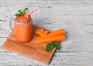 Bir temiz Detoks iki yüzlü kokteyl üstten görünüm bir gri tablosudur arka planda. Sağlıklı havuç içecek bir mason kavanoza. Kopya alanı.