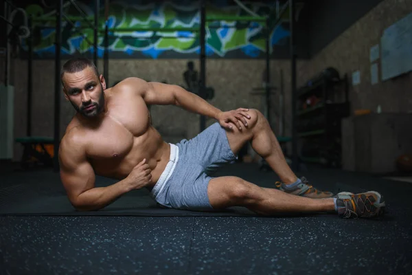 Un primer plano de un hombre musculoso sexy sobre un fondo borroso. Culturista seductor. Concepto de fitness y estilo de vida saludable . — Foto de Stock