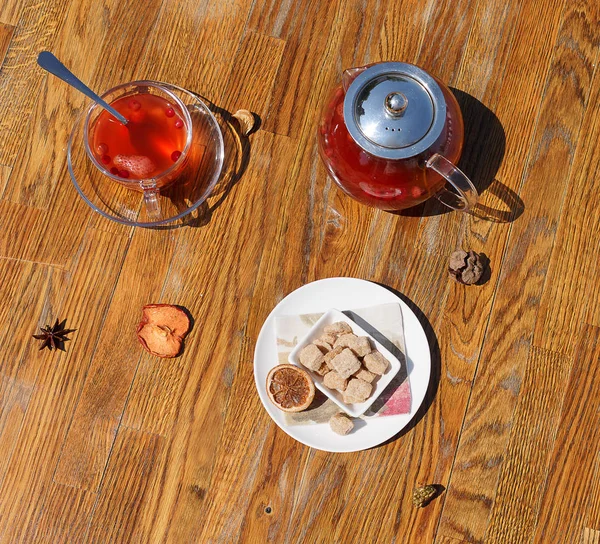 ビスケットと紅茶の平面図です。カリカリのクッキーは、テーブルの背景に赤茶のガラスのコップ。ベリー茶とティーポット. — ストック写真