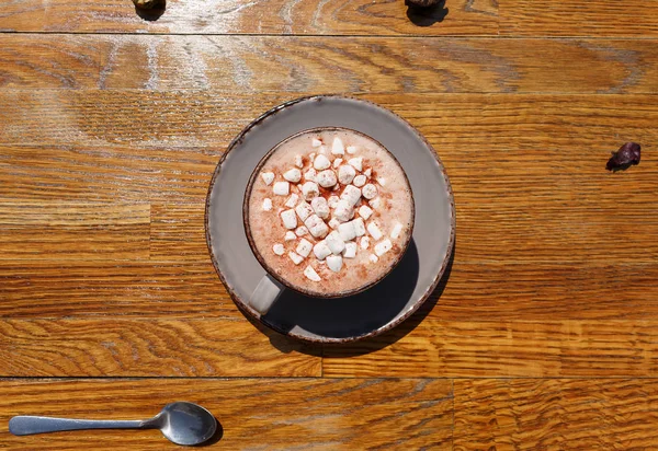 En topp vy av en varm cappuccino med marshmallows. En kopp kaffe på mörka träbord bakgrund. Kopiera utrymme. — Stockfoto