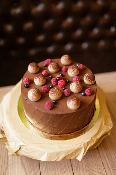 Вид сверху шоколадного торта тирамису с редиской, черной смородиной, посыпанного кокосом на коричневом деревянном фоне . — стоковое фото