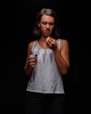 Kadın alarak Antidepresanlar. Bir hastanın hapları siyah bir arka plan ile. Stres, anksiyete, depresyon tedavi kavramı.