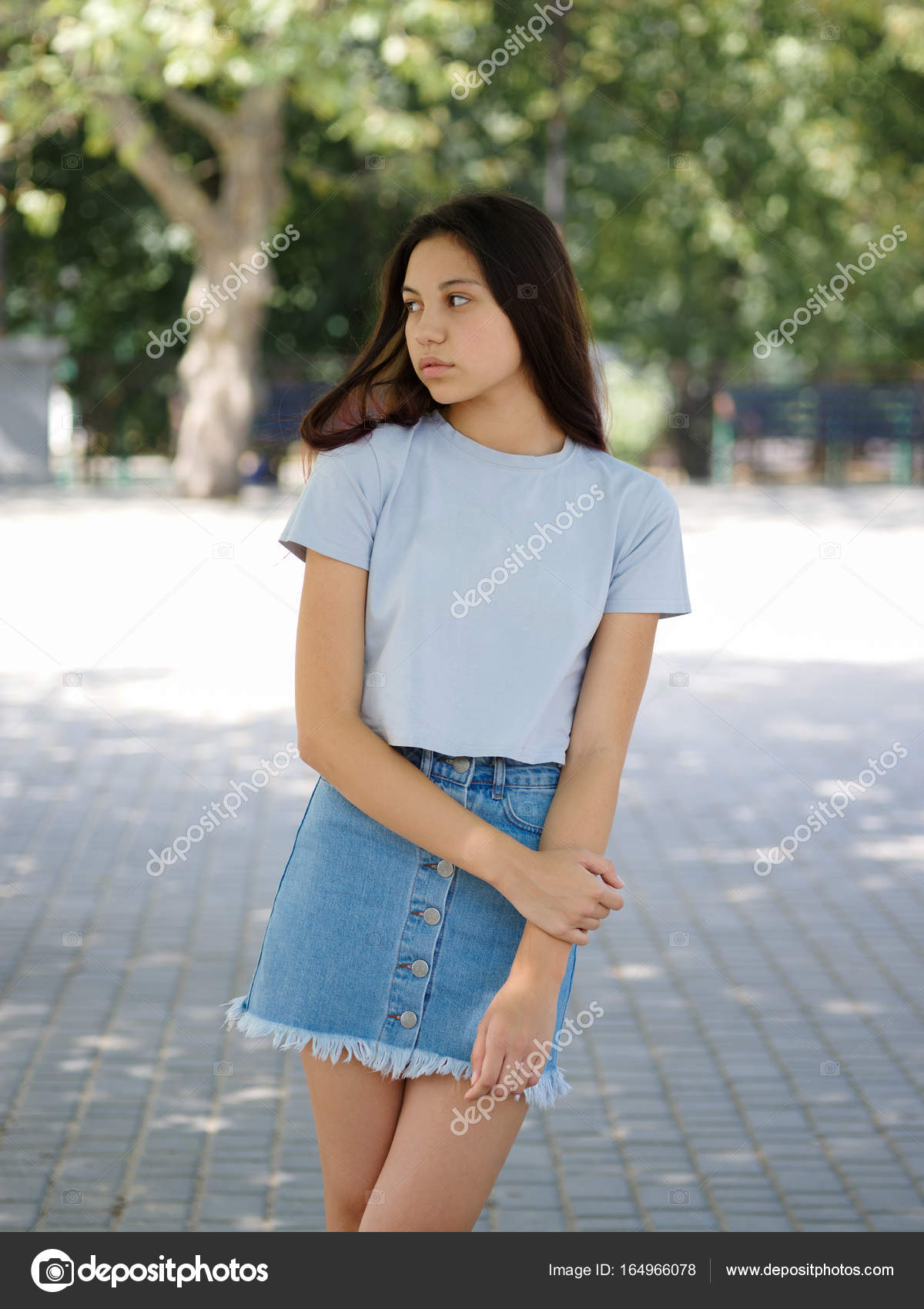 A cute young girl in casual clothes on a natural blurred