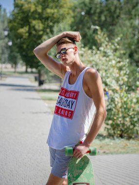 Güzel, düşünceli biri ile bir longboard üzerinde sokak arka plan bulanık. Spor, etkinlikler, leisure kavramı.