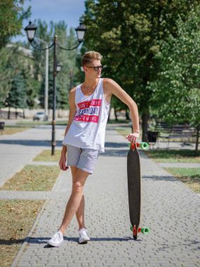 Bir kaykay üzerinde doğal arka plan bulanık bir moda genç hipster adam. Sağlıklı ve aktif yaşam tarzı.