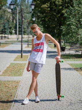 Bir kaykay üzerinde doğal arka plan bulanık bir moda genç hipster adam. Sağlıklı ve aktif yaşam tarzı.