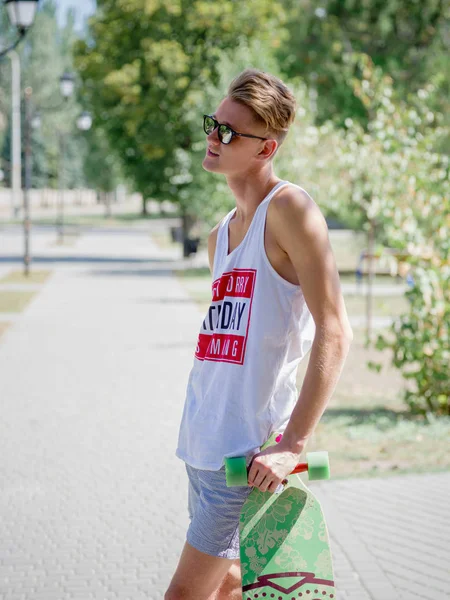 Güzel, düşünceli biri ile bir longboard üzerinde sokak arka plan bulanık. Spor, etkinlikler, leisure kavramı.