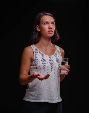 Kadın siyah bir arka plan üzerinde ilaç alarak vurguladı. Çekici erkek uyuşturucu prescripted. Sağlık, vitamin, tıp kavramı.