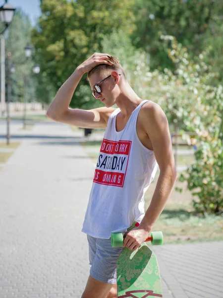 Güzel, düşünceli biri ile bir longboard üzerinde sokak arka plan bulanık. Spor, etkinlikler, leisure kavramı.