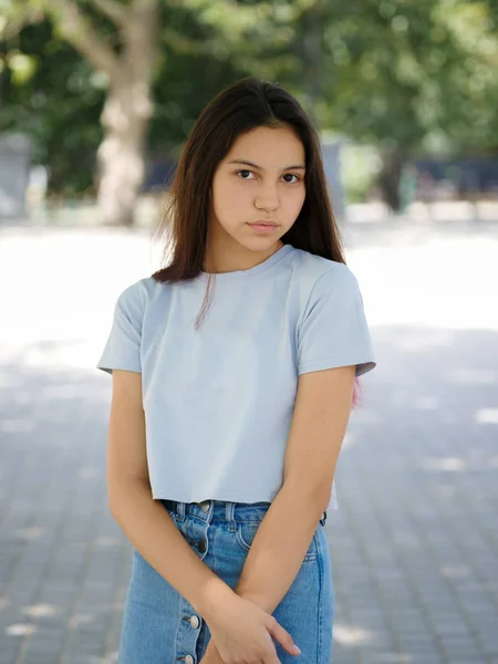 En söt ung tjej i casual kläder på en naturlig suddig bakgrund. Urban, mode och ungdom koncept. Kopiera utrymme. — Stockfoto
