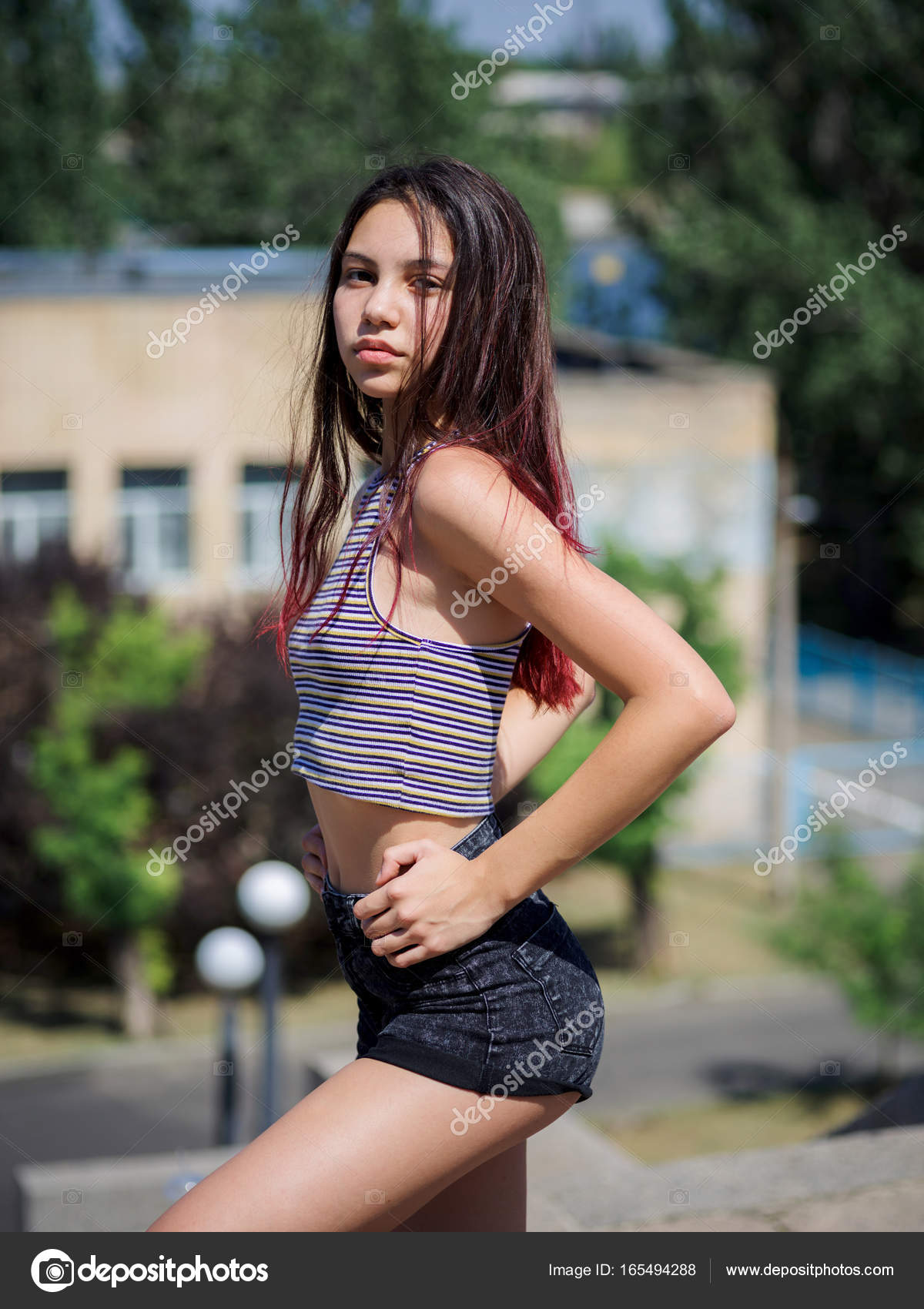 An attractive hipster girl in casual clothes sitting on an urban