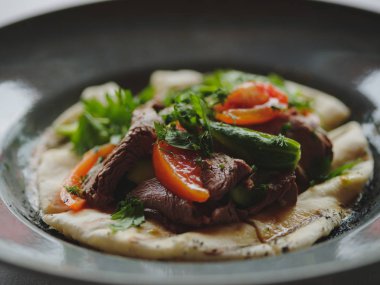 Bir restoran yemek close-up. Kafeterya öğle yemeği bulanık bir arka plan üzerinde servis. Izgara sebze ve et biftek bir ekmek üzerinde.
