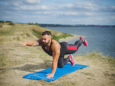 Atletik güçlü adam pratik zor yoga açık havada poz. Genç erkek, pratik Yoga açık havada. Sabah güneşi altında dış eğitim.