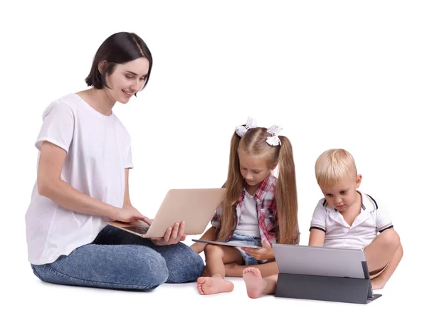Μια όμορφη γυναίκα που ενώνει τα παιδιά της στις σύγχρονες τεχνολογίες απομονωθεί σε λευκό φόντο. — Φωτογραφία Αρχείου