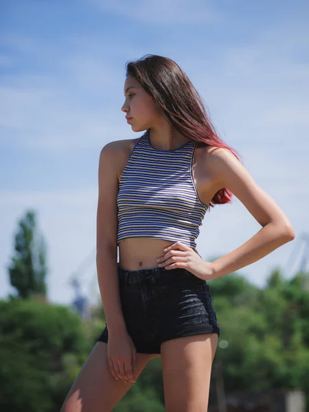 Um retrato de uma adolescente encantadora em roupas de verão posando em um fundo natural. Moda, conceito de juventude. Espaço de cópia . — Fotografia de Stock