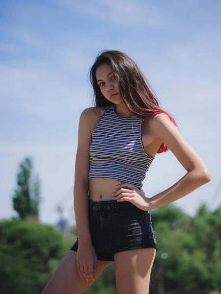 Um retrato de uma adolescente encantadora em roupas de verão posando em um fundo natural. Moda, conceito de juventude. Espaço de cópia . — Fotografia de Stock