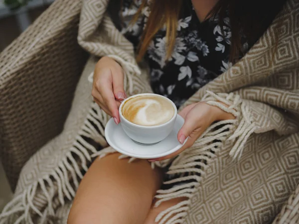 Крупним планом дівчина п'є каву. Прекрасний латекс у чашці. Жінка тримає каву на розмитому фоні кафе . — стокове фото