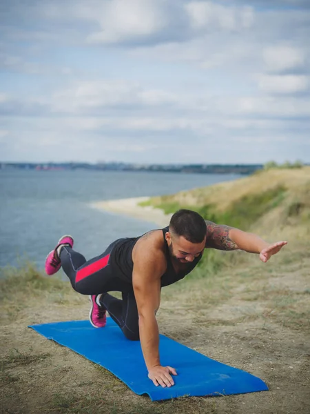 Sağlıklı kişi Nehri yakınında yeşil dağ dışında yoga uygulamaları. Erkek eğitim, hardowking adam.