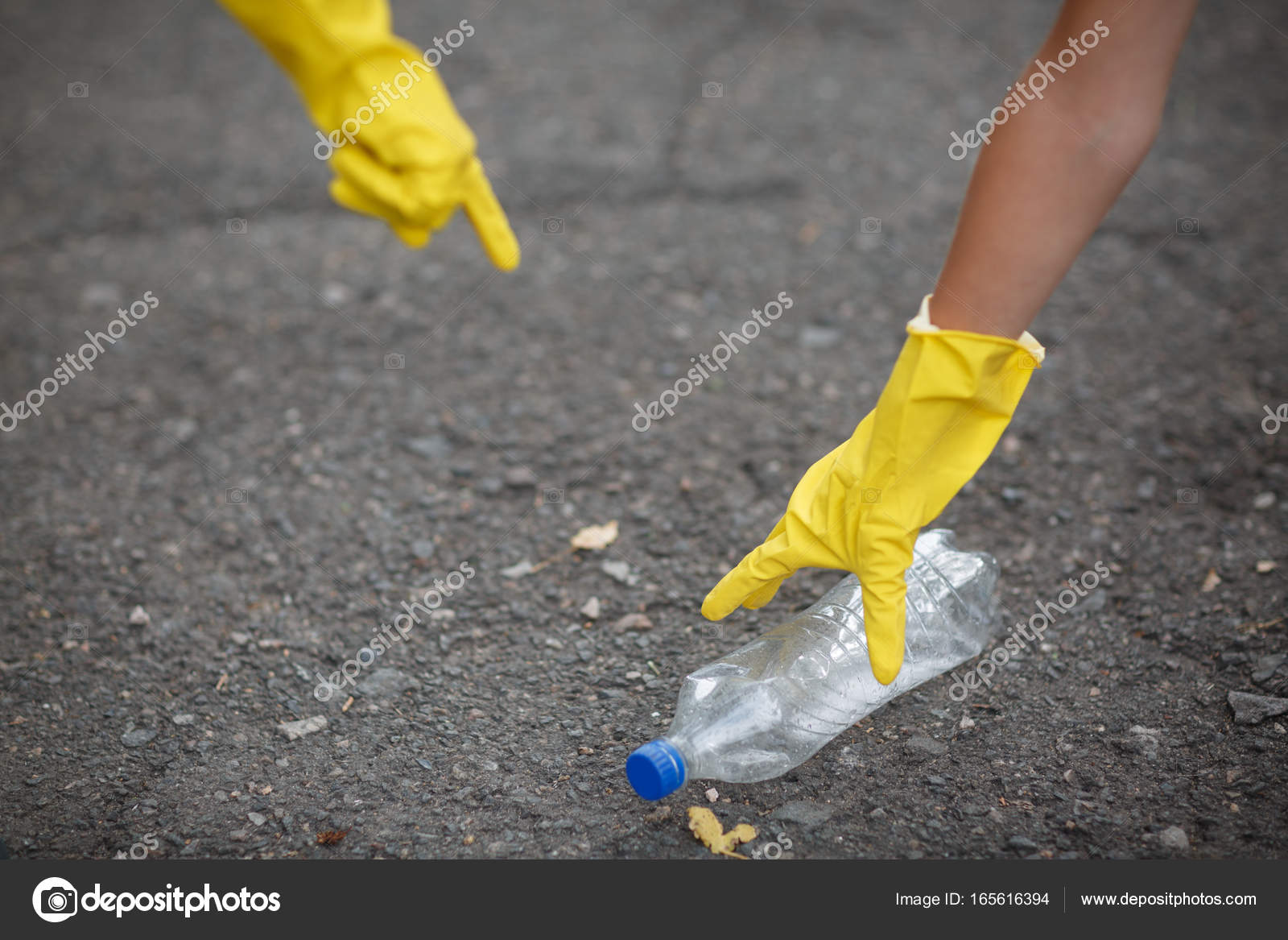 Childs Hands In Yellow Latex Gloves Picking Up A Plastic Bottle On