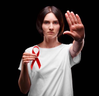AIDS durdurmak. Siyah bir arka plan üzerinde kırmızı kurdele tutan bir kız. AIDS insanlarla destekler. Sağlık bilinci kavramı.