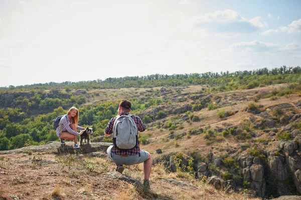 Fotograf, der ein schönes Mädchen draußen fotografiert. Touristisches Fotoshooting vor einem natürlichen Hintergrund. Kopierraum. — Stockfoto