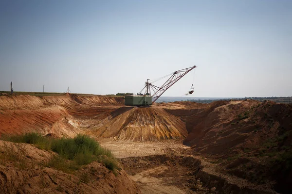 Gele enorme metalen mobiele kraan op een blauwe hemelachtergrond. Een industriële bewegende machine in de put van de Stichting. Kopiëren van ruimte. — Stockfoto