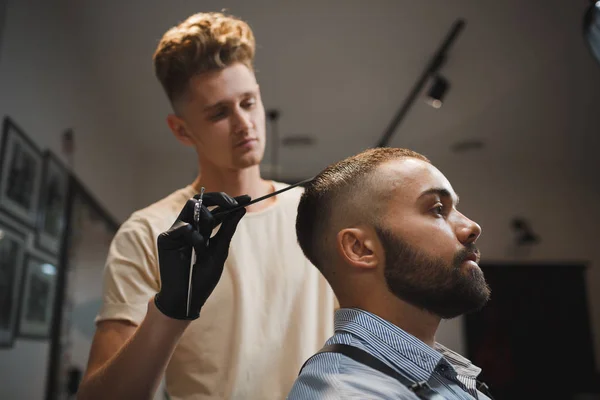 Yakışıklı bir adam bir saç kesimi tarafından Kuaför berber bir arka plan üzerinde oluyor. Güzellik Salonu çekici bir adam. — Stok fotoğraf