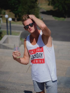 Ciddi düşünceli adam saçını düz bir sokak arka plan bulanık üzerinde koyar. Açık havada, gençlik, eğlence kavramı.