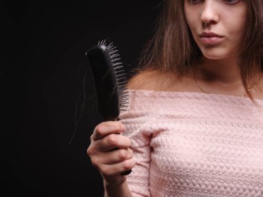 Kadın saç sorunları siyah bir arka plan ile vurguladı. Kırılgan saç için vitaminler. Saç tedavi kavramı. Kopya alanı.