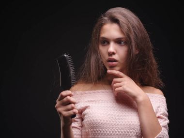 Kadın saç sorunları siyah bir arka plan ile vurguladı. Kırılgan saç için vitaminler. Saç tedavi kavramı. Kopya alanı.