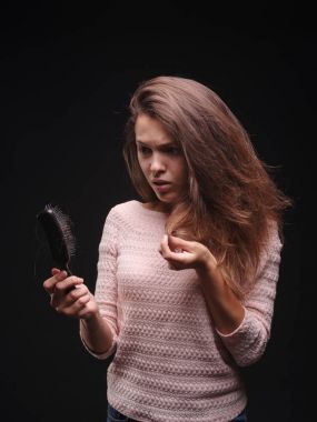 Kadın saç sorunları siyah bir arka plan ile vurguladı. Kırılgan saç için vitaminler. Saç tedavi kavramı. Kopya alanı.