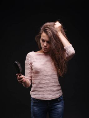 Kadın saç sorunları siyah bir arka plan ile vurguladı. Kırılgan saç için vitaminler. Saç tedavi kavramı. Kopya alanı.