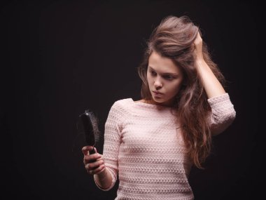 Kadın saç sorunları siyah bir arka plan ile vurguladı. Kırılgan saç için vitaminler. Saç tedavi kavramı. Kopya alanı.