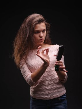 Kadın saç sorunları siyah bir arka plan ile vurguladı. Kırılgan saç için vitaminler. Saç tedavi kavramı. Kopya alanı.