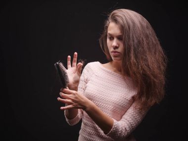 Kadın saç sorunları siyah bir arka plan ile vurguladı. Kırılgan saç için vitaminler. Saç tedavi kavramı. Kopya alanı.