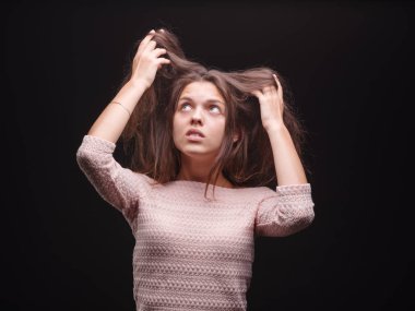 Kadın hasta saçları siyah bir arka plan üzerine çekerek şok. Muhteşem bir kadın saçı mutsuz. Saç rutin kavramı.