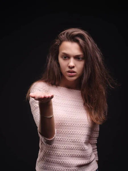 Sad woman holding tangled hair on the black background. Tuft of hair on a girls hand. Hair loss concept. Copy space.