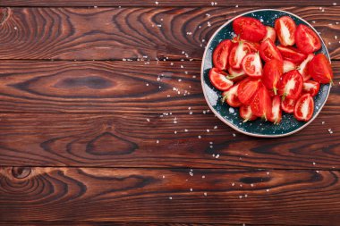 Ahşap arka plan üzerinde kesme sağlıklı domates yakın çekim kase. Ev yapımı domates salatası.