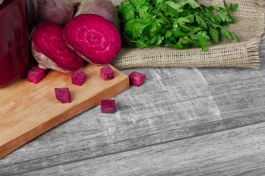 Bütün ve dilimlenmiş beetroots, maydanoz ve içecek bir kesme tahtası ve ahşap arka plan. Sebze Bahçe.
