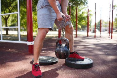 Bir adam kendi ayakları üzerinde egzersizleri yapıyor. Sportif ve sağlıklı genç adam açık havada egzersiz kusursuz bir beden ile.