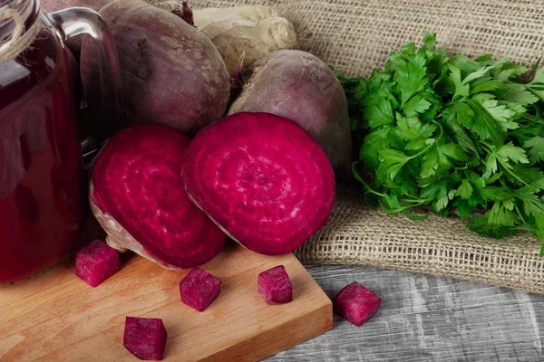 Bütün ve dilimlenmiş beetroots, maydanoz ve içecek bir kesme tahtası ve ahşap arka plan. Sebze Bahçe.