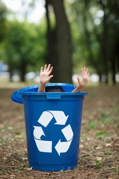 Girl in blue recyling waste bin have fun inside. Concept of environmental protection. Colorful boxes. — Stock Photo, Image