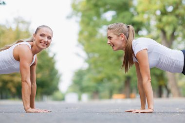 Park arka plan üzerine açık havada şınav fitness kızlar. Sportif kızlar. Egzersiz kavramı. Kopya alanı.
