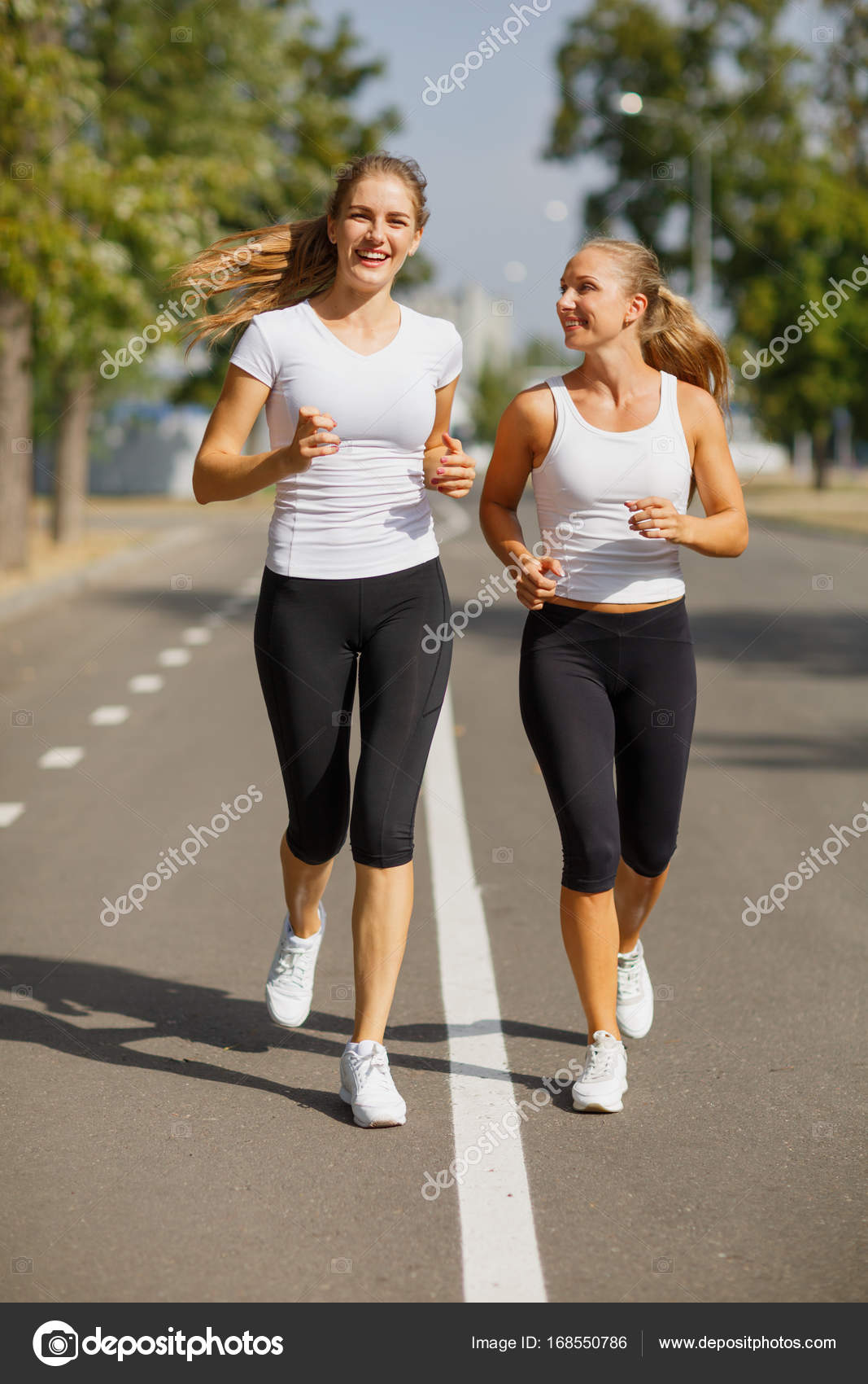 Gorgeous girls running on the blurred background. Sporty youth