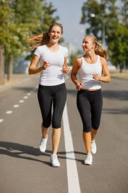 Güzel kızlar bulanık arka plan üzerinde çalışan. Sportif gençlik. Sabah koşu kavramı.