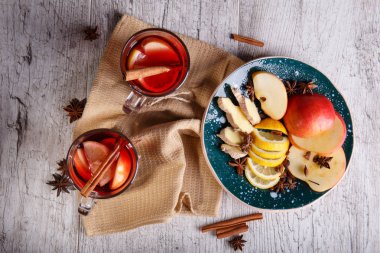 Tablo arka plan üzerinde kesme meyve bir tabak yanında baharatlı kırmızı çay bardak. Aile içi sağlıklı kahvaltı.