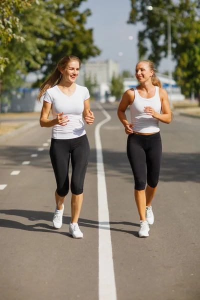 Güzel kızlar bulanık arka plan üzerinde çalışan. Sportif gençlik. Sabah koşu kavramı. — Stok fotoğraf