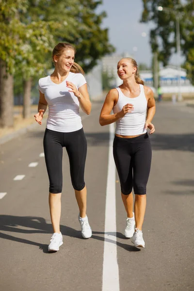 Güzel kızlar bulanık arka plan üzerinde çalışan. Sportif gençlik. Sabah koşu kavramı. — Stok fotoğraf